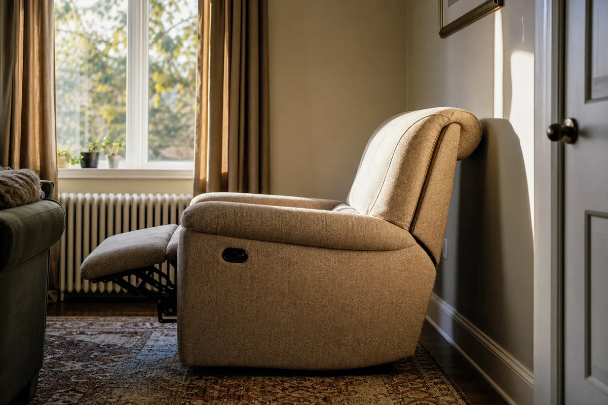 Side view of a beige fabric wall-hugger recliner fully extended next to a cream wall and a closed door