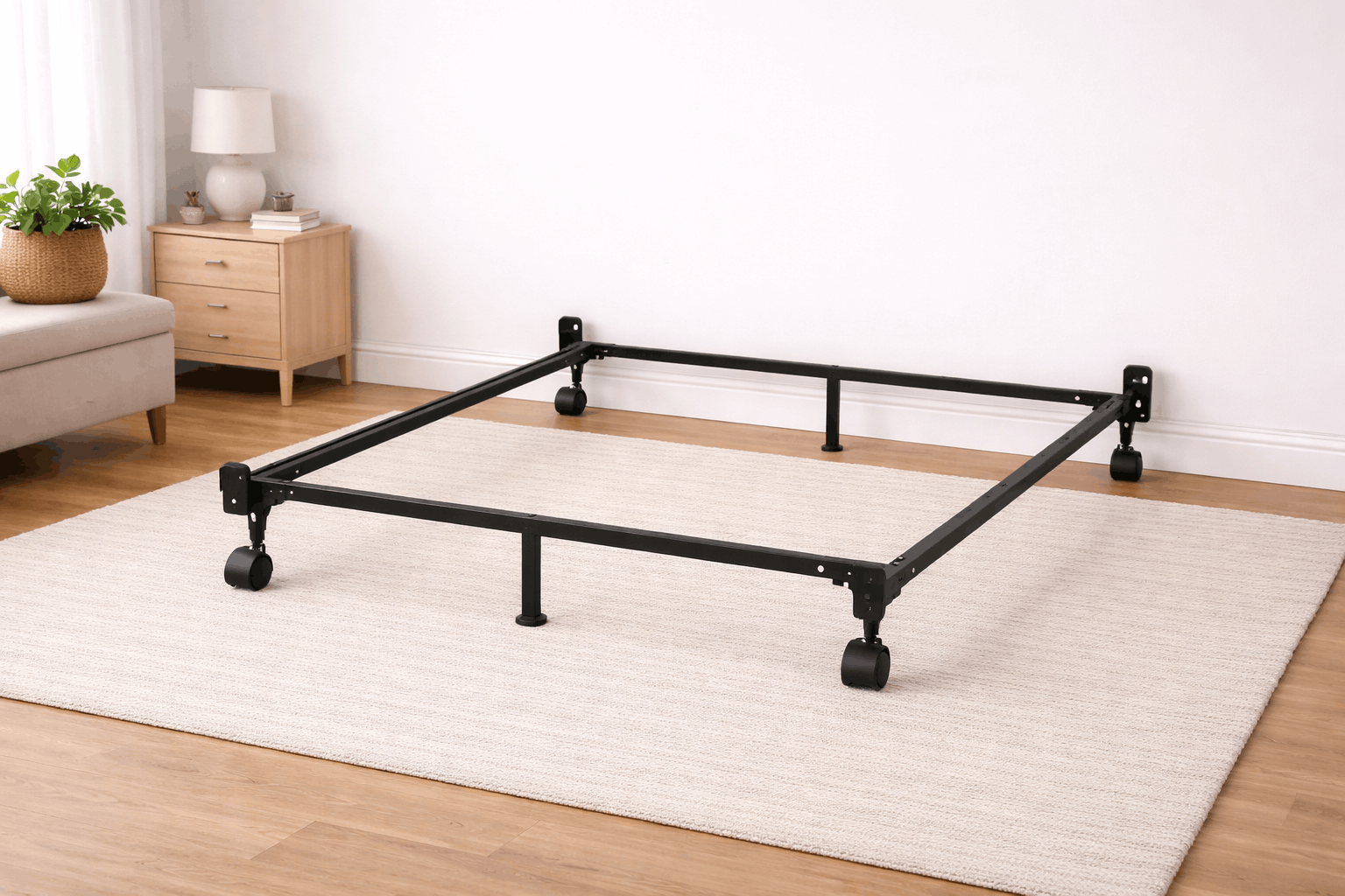 Black metal bed frame with caster wheels and center support leg in a bright neutral bedroom setting.