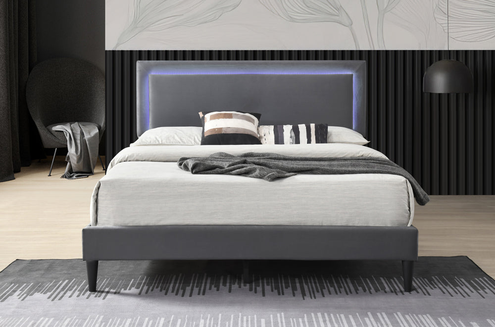 Portside platform bed in charcoal linen with LED-lit headboard, grey rug, and a chair beside dark curtains