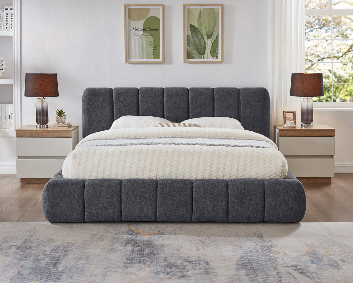 Grey Fairview Platform Bed viewed head-on with vertical channel upholstery beneath framed botanical art and beside lamps