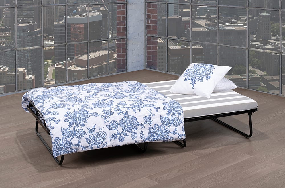 Folding metal bed with a black frame, white mattress, and blue floral bedding.