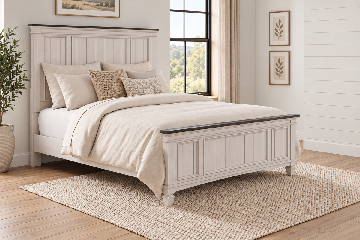Natasha antique white bed frame with a panel headboard, matching footboard and dark top trim, styled with bedding in a bedroom.