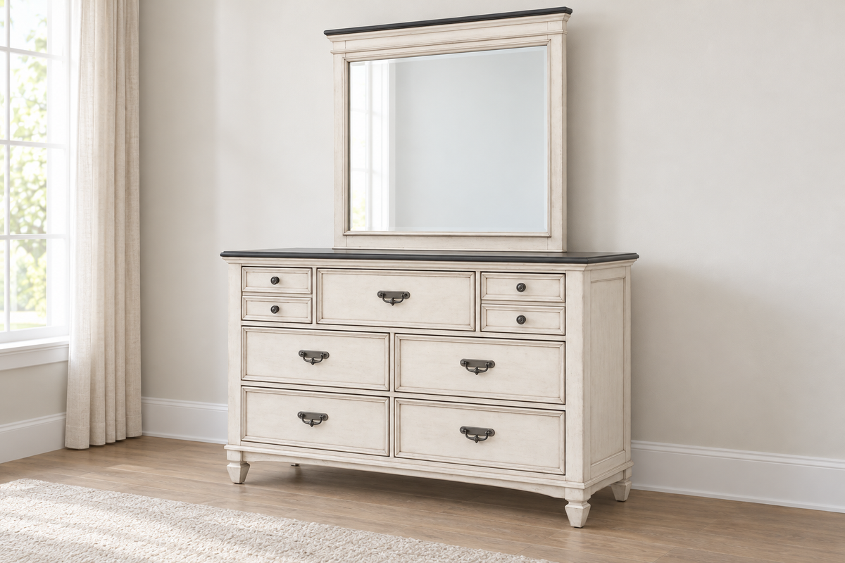 Natasha antique white dresser with a dark top, metal handles and round knobs, shown from an angle with the matching mirror, sold separately.