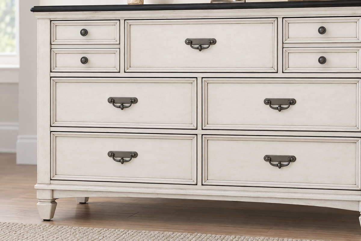 Close-up of the Natasha antique white dresser showing drawer fronts, metal handles, round knobs and the dark top.