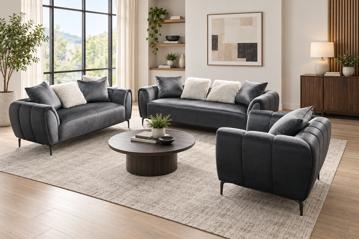 Sam grey sofa, loveseat and armchair arranged around a round coffee table in a furnished living room.