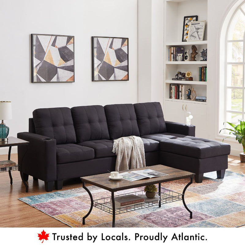 Black reversible sectional sofa with cup holders and tufted fabric cushions.