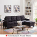 Black reversible sectional sofa with cup holders and tufted fabric cushions.