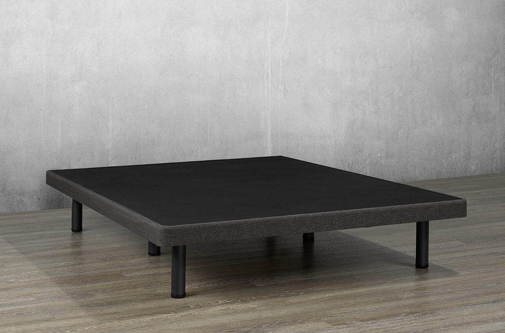 Dark gray upholstered platform bed base with black support legs in a minimal room setting.