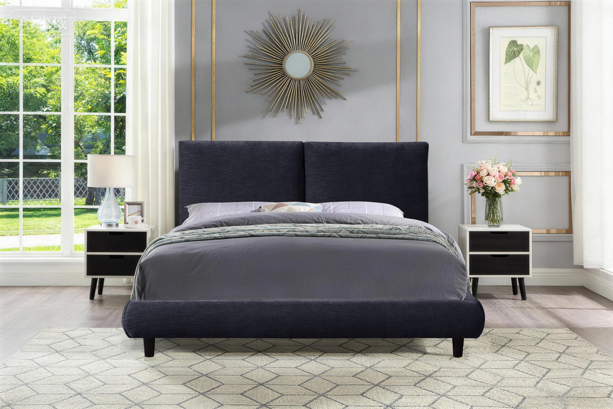 Midnight blue Cunard Platform Bed seen from the foot, textured upholstery with bedding, floral bouquet on bedside