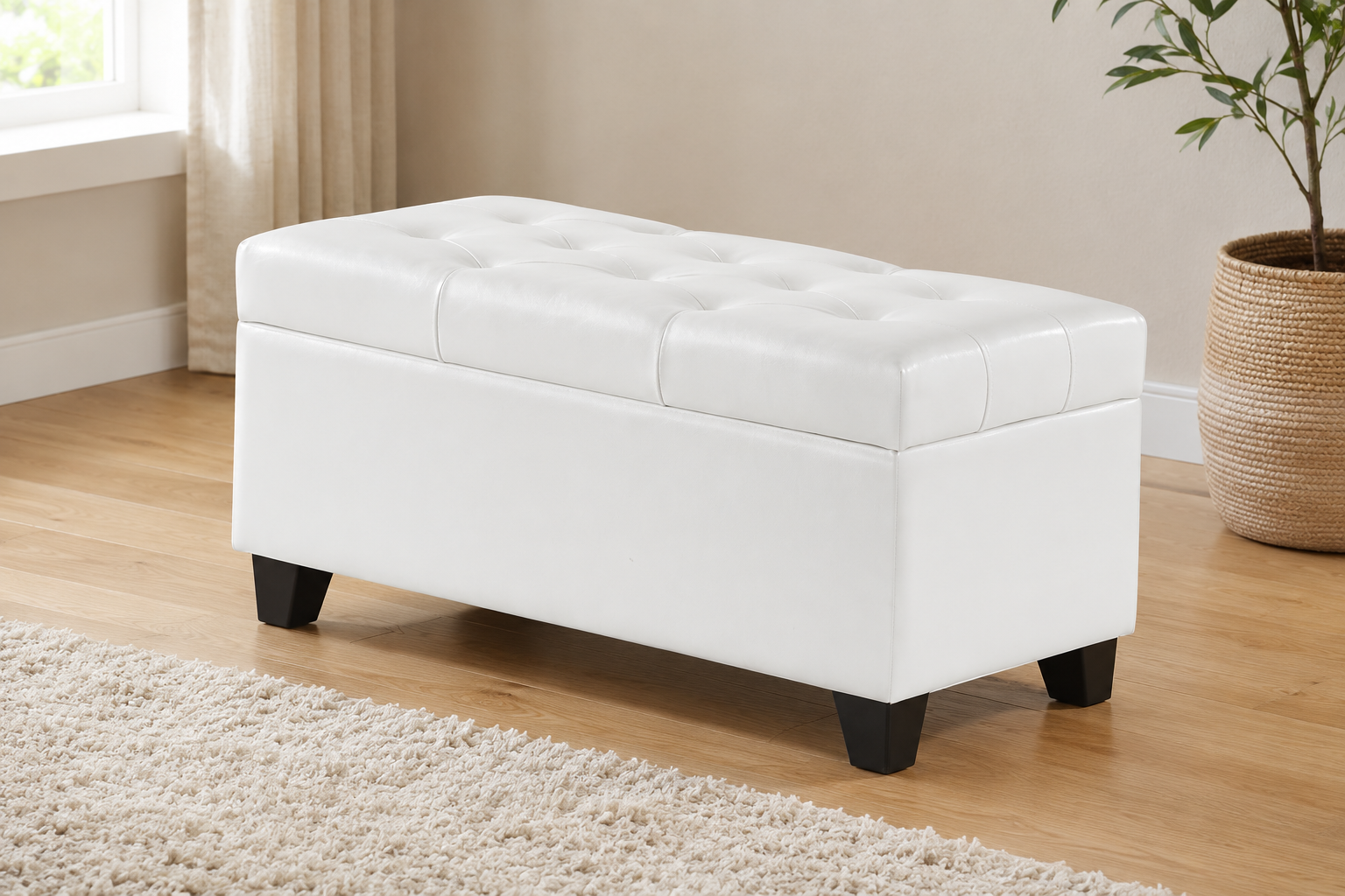 White upholstered storage bench with a button-tufted top and dark tapered legs in a modern neutral room.