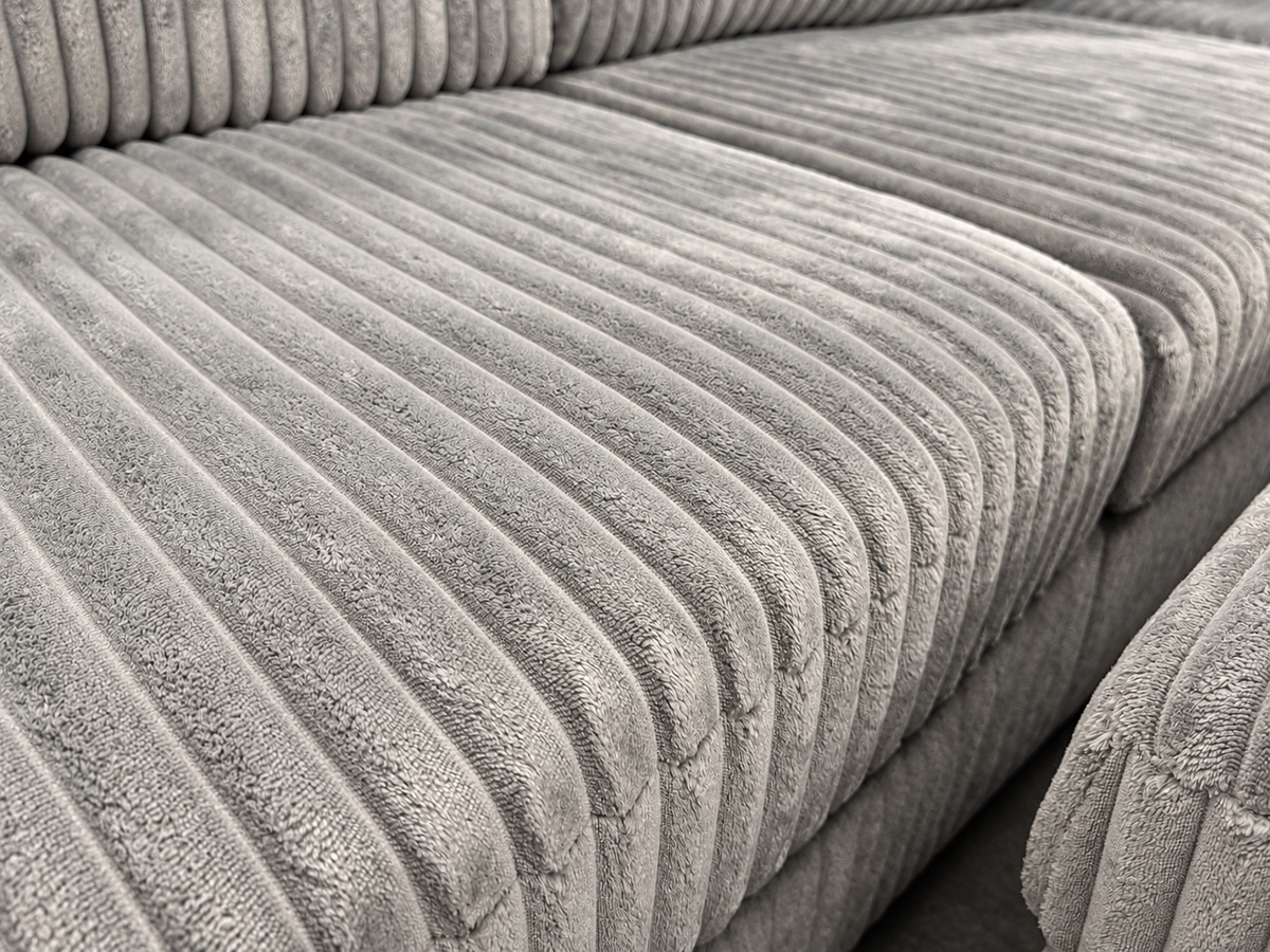 Close-up of the Aspan grey sectional sofa seat cushions showing the ribbed corduroy fabric texture