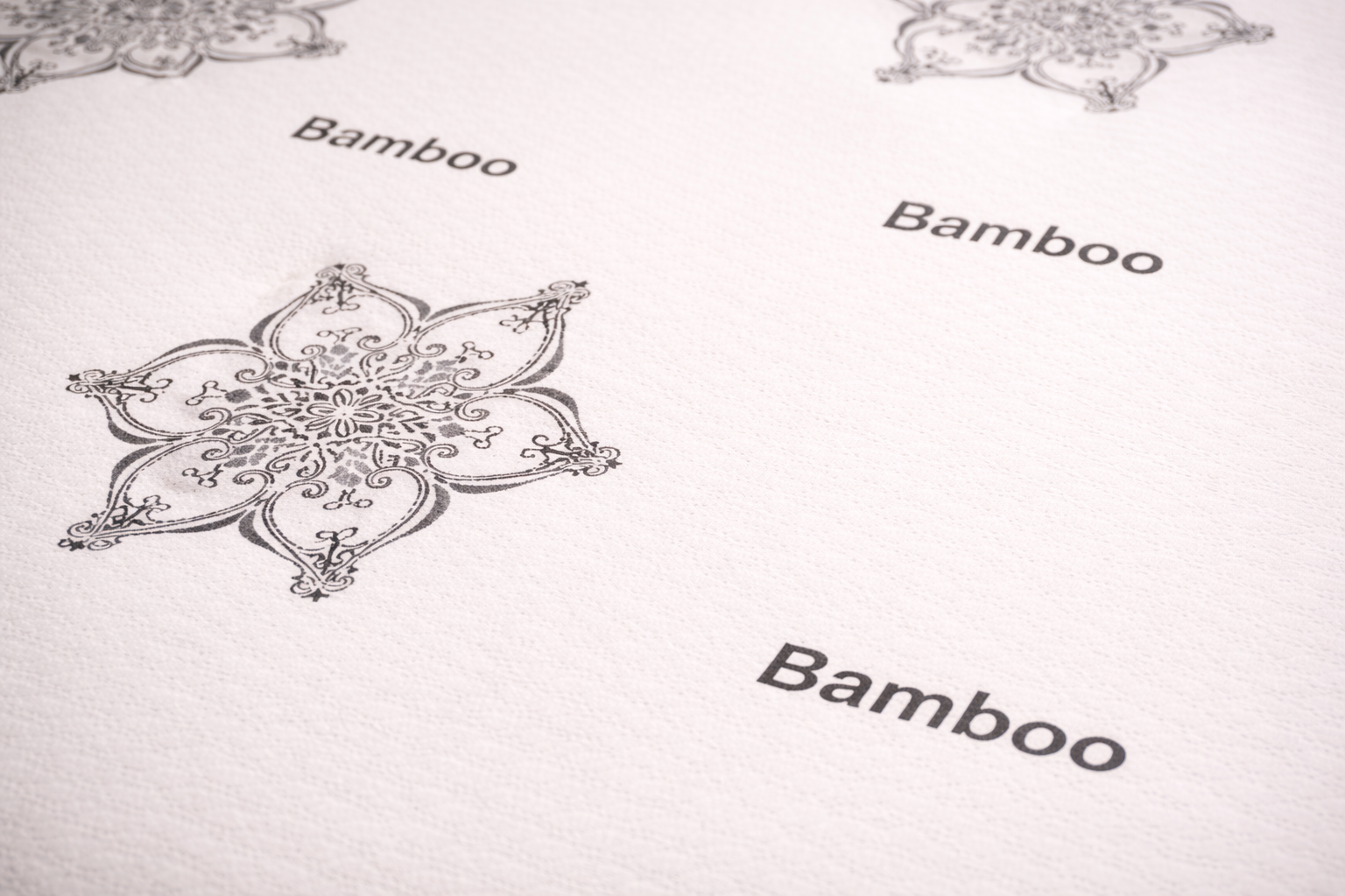 Close-up of smooth-top bamboo mattress fabric with floral medallion print and Bamboo text