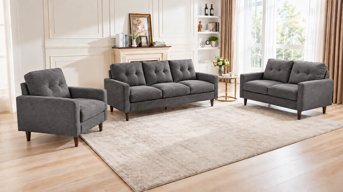 Bella dark grey 3-piece sofa set with a sofa, loveseat and armchair, tufted backs and wooden legs in a living room.