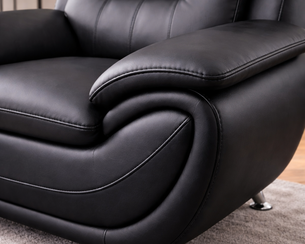 Close-up angled view of black leather sofa showing leather texture and stitching detail