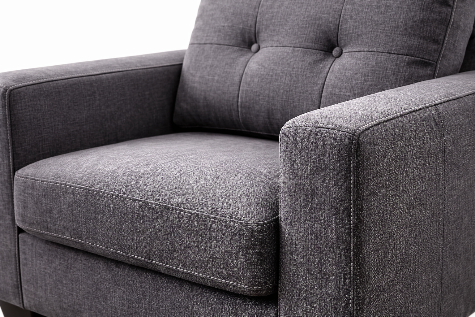 Close-up angled view of charcoal linen fabric armchair showing woven texture and stitching detail