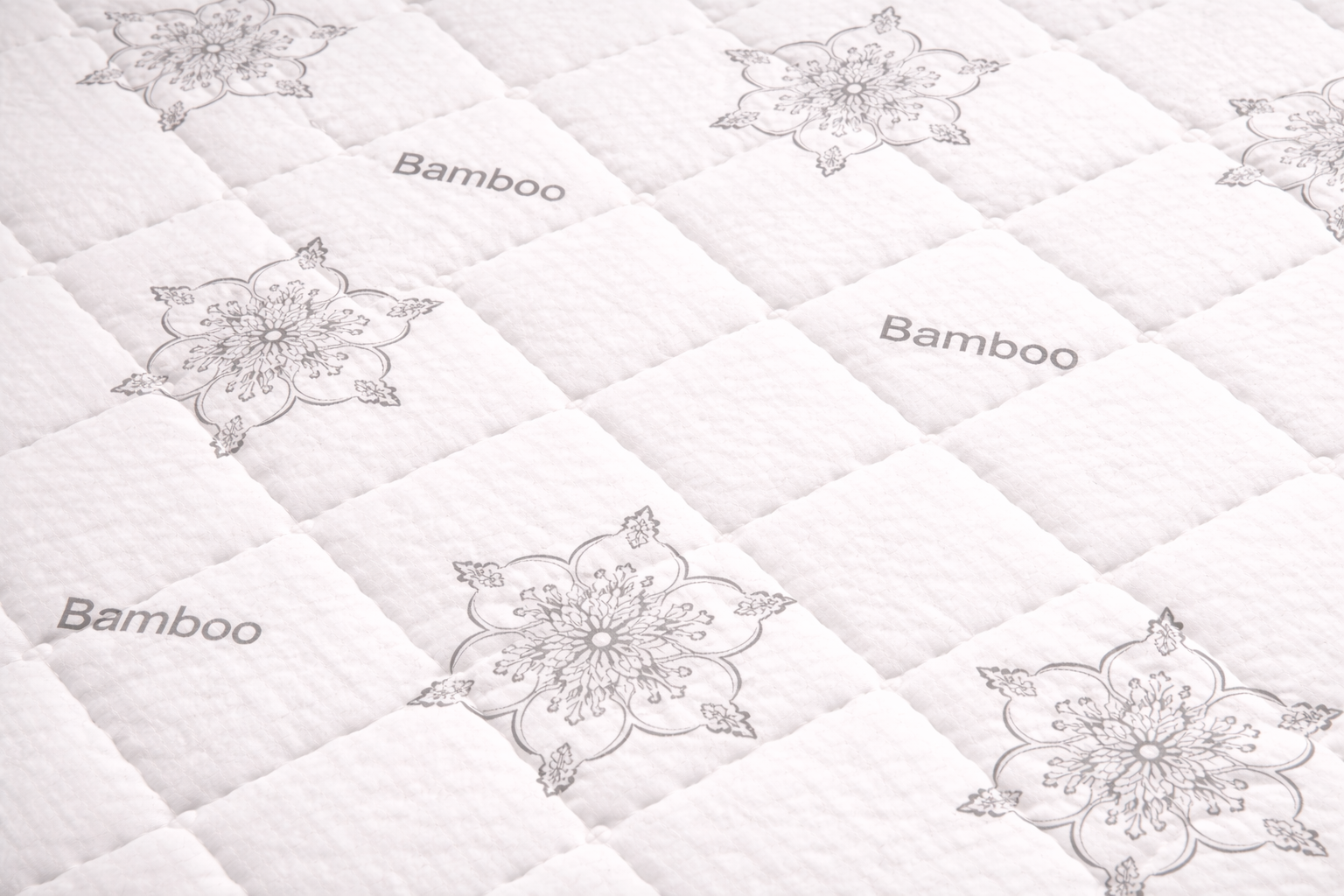 Close-up of Euro Canada bamboo quilted mattress surface with floral pattern under professional lighting