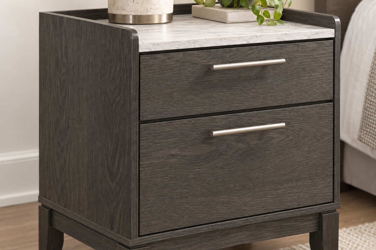 Detail of the Juliet grey nightstand showing wood-grain drawer fronts, metal handles and a light-coloured top.