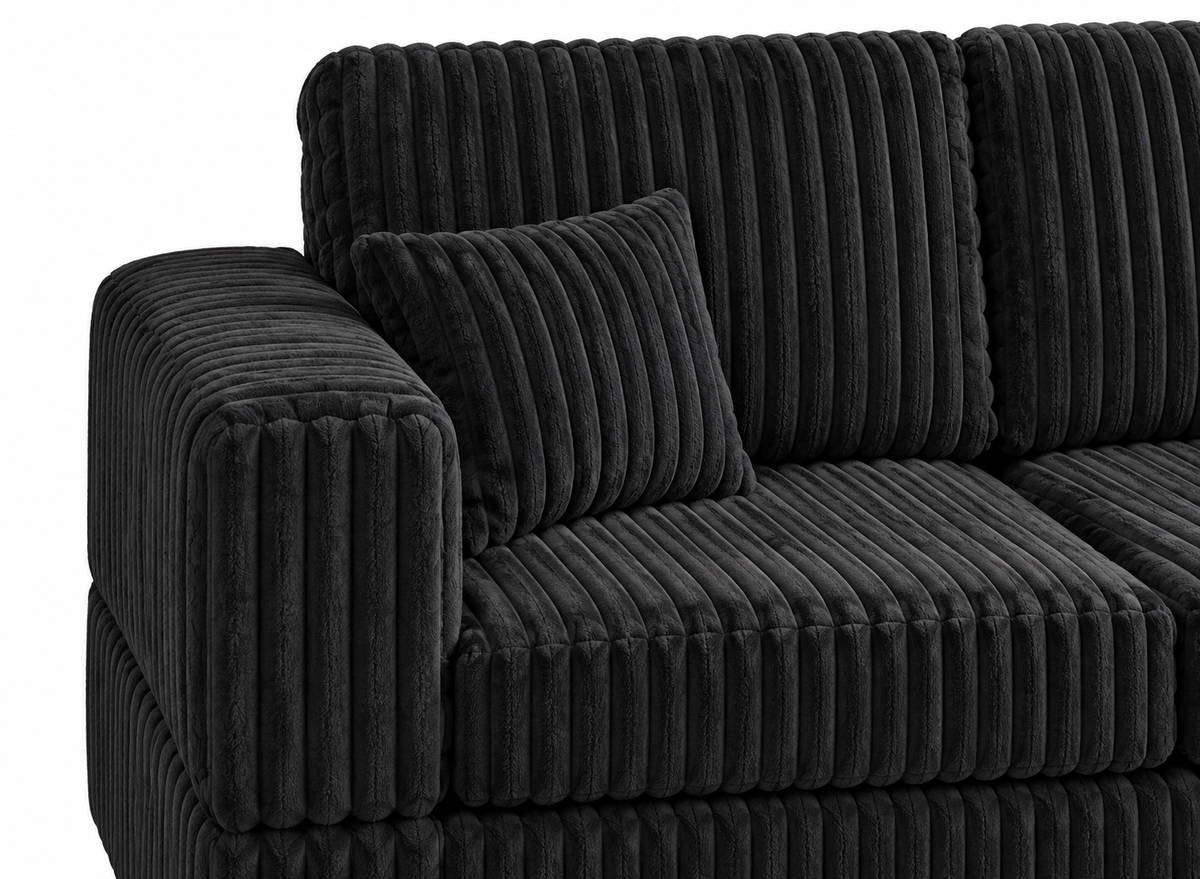 Close-up of Kennedy Sectional Black showing left arm, back cushions and one small matching pillow in black ribbed fabric
