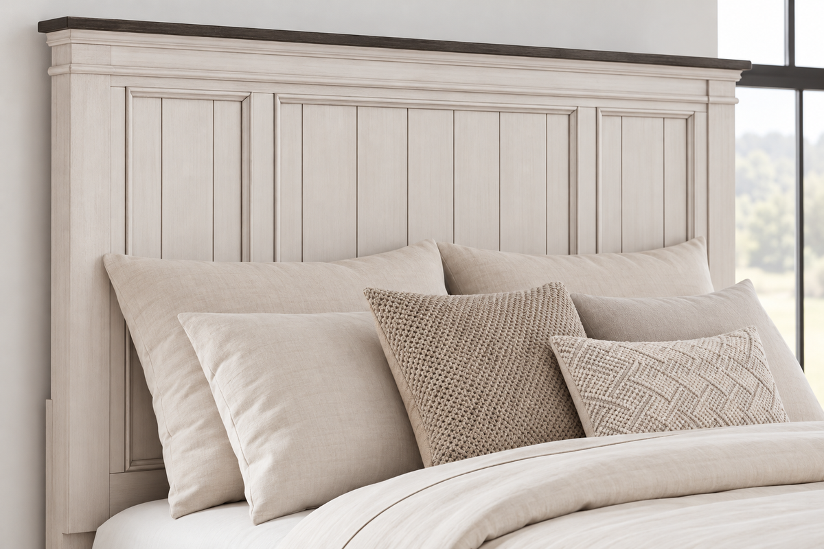 Close-up of the Natasha antique white bed showing the panel headboard, moulded frame and contrasting dark top trim.