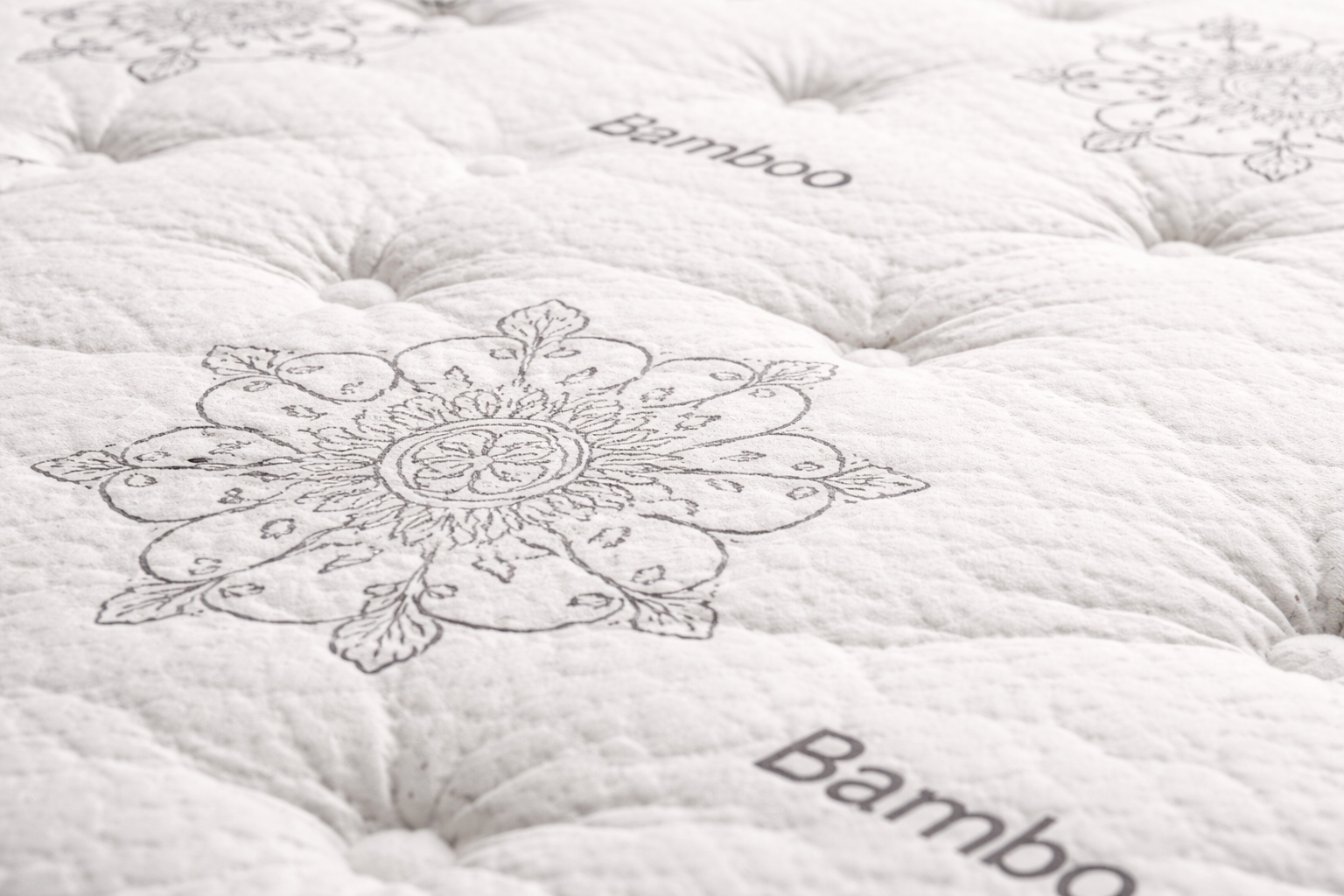 Close-up detail of Royal Premium Double Sided pillow top mattress showing tufted bamboo quilted surface with floral pattern design.